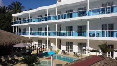 a large white building with a swimming pool and a resort at El Cabarete Spa Resort all-Inclusive in Cabarete