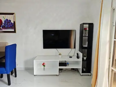 a living room with a tv and a white cabinet at Residencial Las Estrellas in Boca Chica