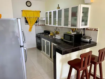 a kitchen with a black counter top and a refrigerator at Higuey Center City in Higuey