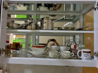 a shelf with cups and dishes in a kitchen at Higuey Center City in Higuey