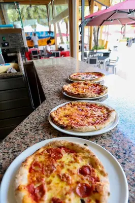 four pizzas on plates sitting on a table at Boca Beach Residence hotel in Boca Chica
