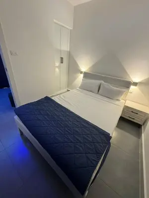 a small bedroom with a large bed with a blue light at Boca Beach Residence hotel in Boca Chica