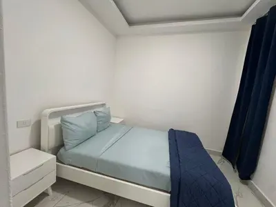 a small bedroom with a bed with blue sheets at Boca Beach Residence hotel in Boca Chica