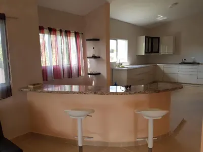 a kitchen with a large counter with two stools at Caleton Group in Río San Juan