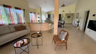 a living room with a couch and chairs and a kitchen at Caleton Group in Río San Juan