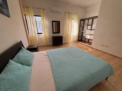 a bedroom with a large bed with blue and white sheets at Caleton Group in Río San Juan
