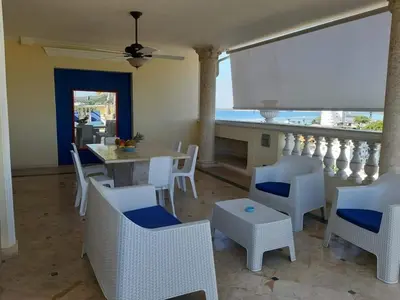 a dining room with white chairs and a table at Villa Florencia in Boca Chica