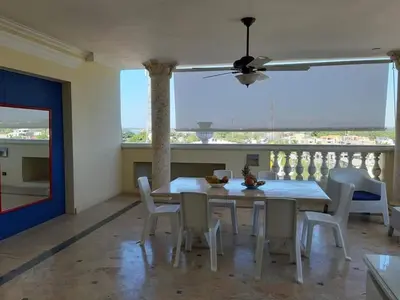 a dining room with a table and chairs and a ceiling fan at Villa Florencia in Boca Chica