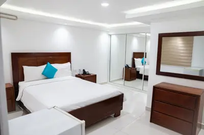 a hotel room with a bed and a mirror at Cataleya Hotel in Santo Domingo