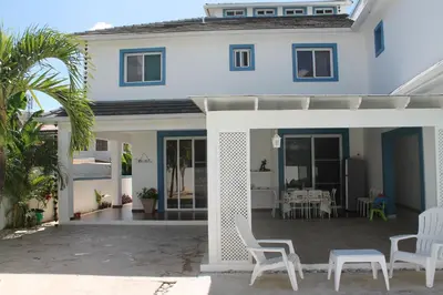a white house with white chairs and a patio at B&B Villa Luna in Bayahibe