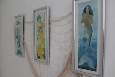 three pictures of mermaids hanging on a wall at B&B Villa Luna in Bayahibe