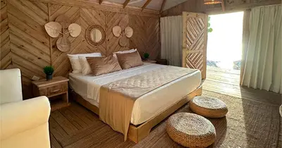 a bedroom with a bed and two tables in a room at Glamping EcoLodge Cueva De Las Aguilas in Pedernales