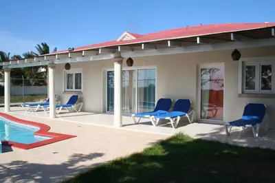 a patio with blue chairs and a swimming pool at Villas Michaela Caribbean in Sosúa