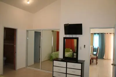 a bedroom with a mirror and a dresser with a television at Villas Michaela Caribbean in Sosúa