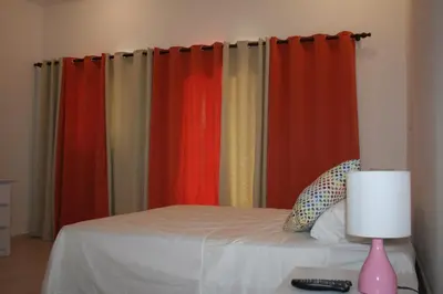 a bedroom with colorful curtains and a bed with a lamp at Villas Michaela Caribbean in Sosúa