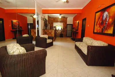 a lobby with couches and chairs in an orange room at Hotel Maison Gautreaux in Santo Domingo