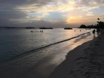 a beach with a group of people in the water at Casita Blanca Bayahibe in Bayahibe