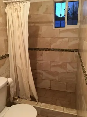 a bathroom with a shower curtain and a toilet at Casita Blanca Bayahibe in Bayahibe