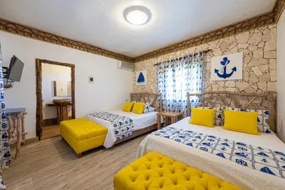 a bedroom with two beds and a mirror at Vista de Águilas Ecolodge in Pedernales