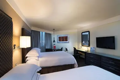 a hotel room with two beds and a flat screen tv at Barceló Santo Domingo in Santo Domingo