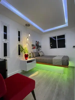 a bedroom with a bed with neon lights in it at Alegria Hostal in Santiago de los Caballeros