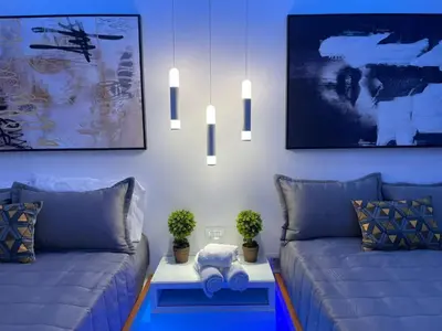 a living room with two blue couches and a table at Alegria Hostal in Santiago de los Caballeros