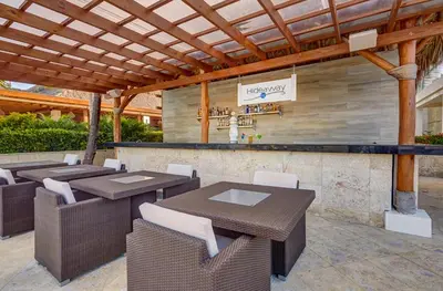 a patio with tables and chairs and a bar at Royalton Hideaway Punta Cana, An Autograph Collection All-Inclusive Resort & Casino - Adults Only in Punta Cana