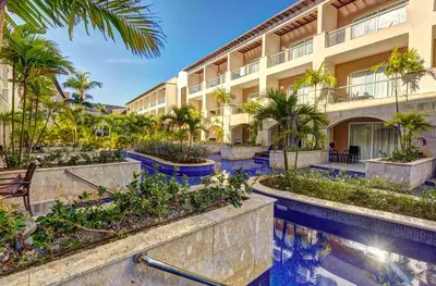 an exterior view of a resort with a swimming pool and palm trees at Royalton Hideaway Punta Cana, An Autograph Collection All-Inclusive Resort & Casino - Adults Only in Punta Cana