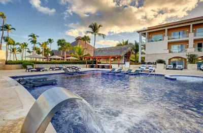 a swimming pool with a water fountain in front of a building at Royalton Hideaway Punta Cana, An Autograph Collection All-Inclusive Resort & Casino - Adults Only in Punta Cana