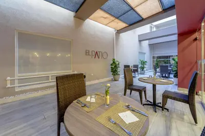 a dining room with two tables and chairs at Novus Plaza Hodelpa in Santo Domingo