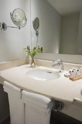 a bathroom counter with a sink and a mirror at Novus Plaza Hodelpa in Santo Domingo