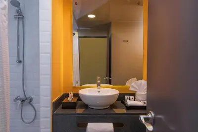 a bathroom with a white sink and a mirror at Novus Plaza Hodelpa in Santo Domingo