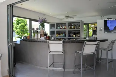 a bar with three stools in a room at Aligio Beachfront Paradise in Las Terrenas