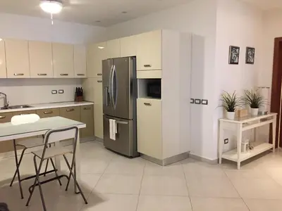 a kitchen with a refrigerator and a table and chairs at Aligio Beachfront Paradise in Las Terrenas