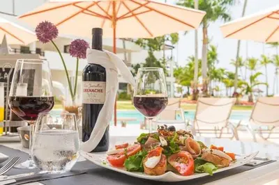 a table with a plate of food and a bottle of wine at Aligio Beachfront Paradise in Las Terrenas