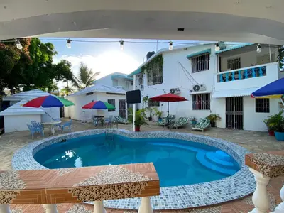 a pool in front of a house with an umbrella at Villa Antonia 16 in Sosúa