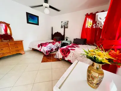 a bedroom with two beds and a vase of flowers on a table at Villa Antonia 16 in Sosúa