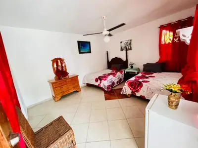 a bedroom with two beds and a dresser in it at Villa Antonia 16 in Sosúa