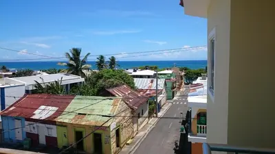 a city street with buildings and the ocean in the background at Luxury Karla Apartments in Las Flores