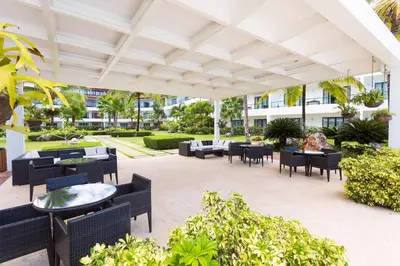 an outdoor patio with tables and chairs at Apartment in Sublime Samana Résidence in Las Terrenas