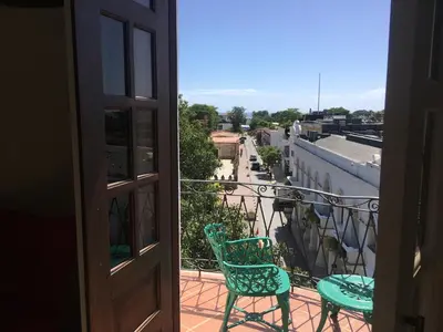 an open door to a balcony with two chairs at Hotel Conde de Penalba in Santo Domingo