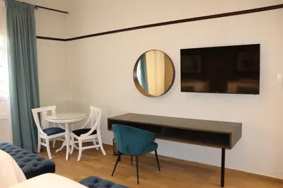 a living room with a piano and a table and chairs at Hotel Conde de Penalba in Santo Domingo