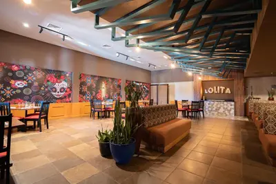 a restaurant with tables and chairs and paintings on the walls at Emotions by Hodelpa Puerto Plata in San Felipe de Puerto Plata