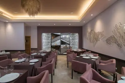 a restaurant with tables and chairs and a chandelier at Emotions by Hodelpa Puerto Plata in San Felipe de Puerto Plata