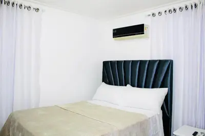 a bed with a black headboard in a room at Apartamento Los Rieles in Santiago de los Caballeros