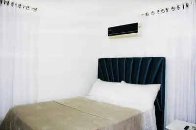 a bedroom with a bed with a black headboard at Apartamento Los Rieles in Santiago de los Caballeros