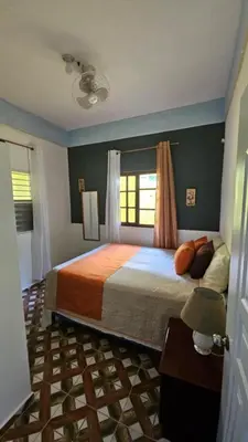 a bedroom with a large bed and a window at Springhouse jarabacoa in Jarabacoa