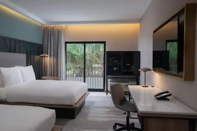 a hotel room with a bed and a desk with a computer at Courtyard by Marriott Santo Domingo in Santo Domingo