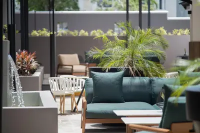 a patio with a couch and chairs and potted plants at Courtyard by Marriott Santo Domingo in Santo Domingo
