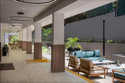 a lobby with a couch and tables and chairs at Courtyard by Marriott Santo Domingo in Santo Domingo